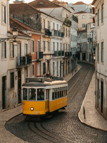 Lisbon Tram 28 rounding a cobbled hill in Alfama